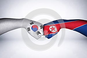 Fist bumping with painted flags of South Korea and North Korea.