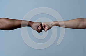 Fist of different skin colors giving fist bump. Conceptual image of race tolerance and stop racism