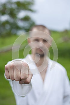 Fist in focus. A karate trainer strikes with a fist.