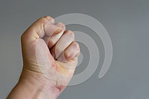 fist on gray background. The concept of domestic violence. Male rudeness and violence. copy space photo