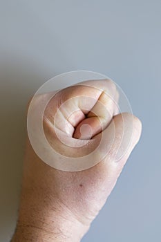 fist on gray background. The concept of domestic violence. Male rudeness and violence. vertical photo