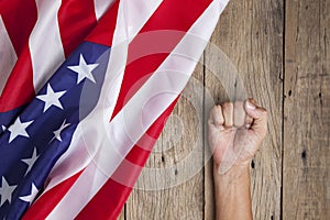 Fist man hand with United States of America flag on old wood background.