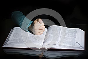 Fist over open book