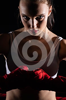 Fist punch into fist. Hands wrapped in boxing tape. Strong abdominal muscles. Athletic body. Strong woman.