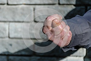 Fist with a thumb between the index and middle fingers, fig sign. Gesture mens hand of negative. Concept of rejection. Closeup