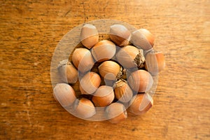 Fistful of ripe hazelnuts on table