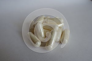 Fistful of white capsules of Acetyl L-Carnitine photo