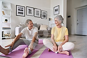 Fit active mature wife and senior husband having fun exercising at home.