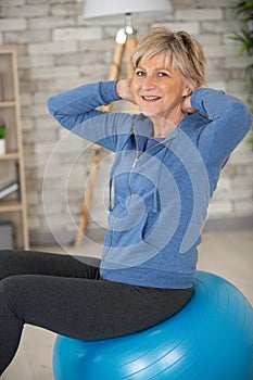 fit aged woman holding blue exercise ball