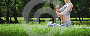 Fit asian woman doing yoga meditation in park fitness and heakthy outdoor concept