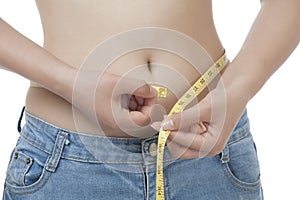 Fit Asian woman measuring her waist on white background