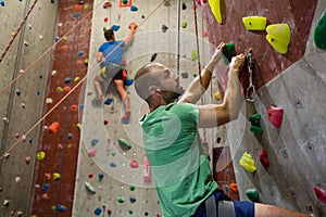 Fit athletes climbing wall in club