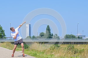 Fit athletic middle-aged man pointing skywards with both hands photo