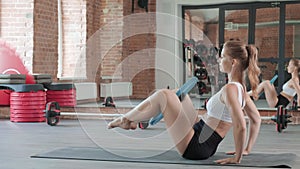 fit athletic woman doing fitness training with pilates ring between knees at gym