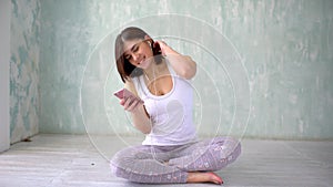 Fit athletic woman is texting sms in sport gym on phone. Portrait of a happy fitness woman using smartphone in gym.