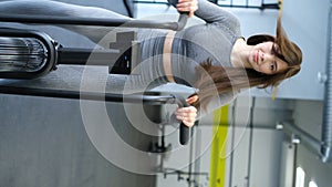 Fit attractive brunette young woman doing exercises on air bike in gym. Fitness, CrossFit.