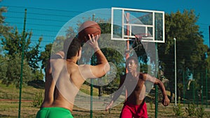 Fit basketball player blocking shot at urban court