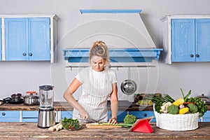 Fit beautiful woman in apron chopping cutting vegetables cooking salad in kitchen, preparing vegetarian food