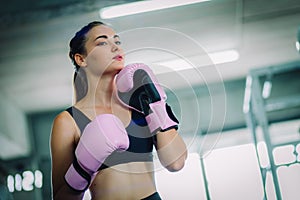 Fit beautiful woman boxer hitting a huge punching bag exercise class in a gym. Boxer woman making direct hit dynamic movement.