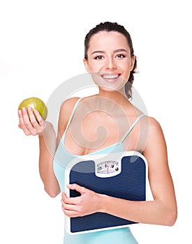 Fit beautiful woman holding weighs and apple
