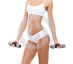 Fit and beautiful woman in swimsuit. Sporty girl with dumbbells. Fitness, diet and healthy lifestyle concept.