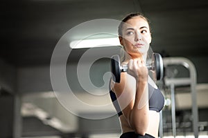 Fit beautiful young woman caucasian posing at the camera in sportswear. Young woman holding dumbbell