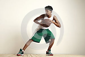 Fit black athlete playing with a vintage basketball