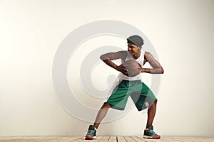 Fit black athlete playing with a vintage basketball