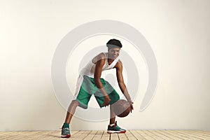 Fit black athlete playing with a vintage basketball