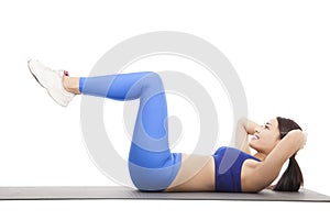 Fit blonde doing pilates core exercise in studio