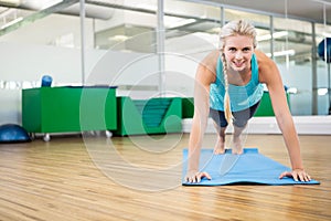 Fit blonde planking on mat photo