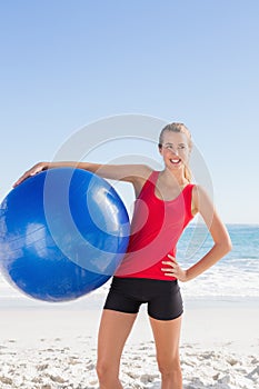 Fit blonde woman holding exercise ball