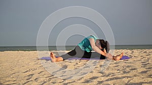 Fit brunette woman make stretching workout exercise at beautiful sea beach