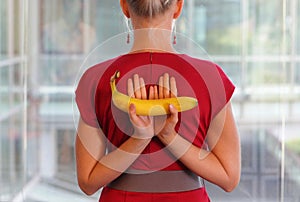 Fit business woman with banana as a healhy snack