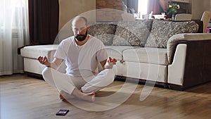 Fit caucasian guy meditating at home.