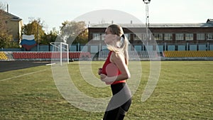 fit caucasian pretty woman in red activewear running outdoors along grass field