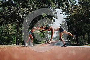Fit couple of athletes performing cartwheels in a sunny park, inspiring outdoor training and promoting better body shape