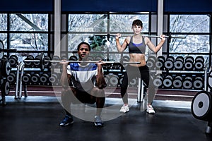 Fit couple exercising with barebell