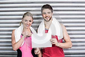 Fit couple holding blank paper