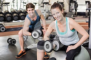 Fit couple lifting dumbbells