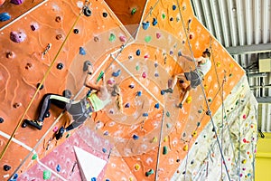 Fit couple rock climbing indoors