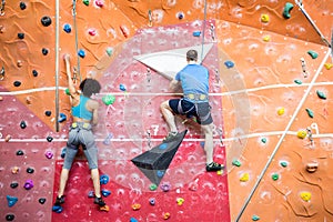 Fit couple rock climbing indoors