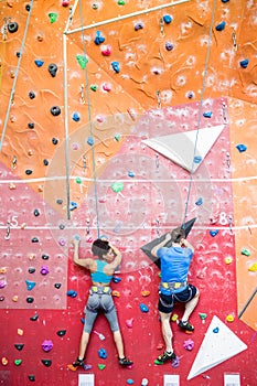 Fit couple rock climbing indoors