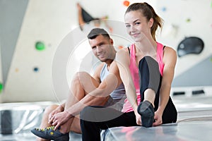 fit couple rock climbing indoors at gym