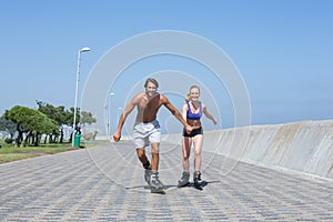 Fit couple rollerblading together on the promenade