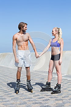 Fit couple rollerblading together on the promenade