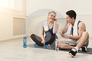 Fit couple with smartphone listening to music