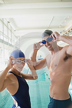 Fit couple swimmers by pool at leisure center