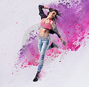 Fit dancer jumping into the paint splash