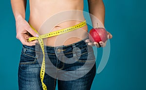 Una mujer cuerpo manzana a medición cinta. saludable idoneidad a comer estilo de vida 